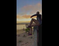 Guy sits on ledge and watches sunset