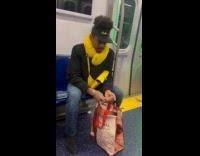 Man opens oyster shell inside subway train