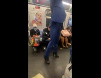 Man on suit wears heels rides subway