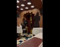 Woman in black jacket poses inside restaurant 