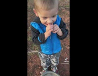 Little boy holding fish bites and drops it 