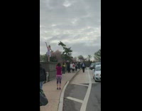 Man on the car roof take pictures of woman in dress