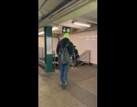 Guy rides blue scooter through subway station 