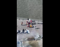 A group of people in cultural clothing dancing by the water