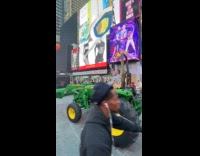 Man drive green farm tractor times square