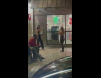 Woman in black crop top poses in front of the convenience store