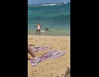 Woman crawl on beach hit behind by waves