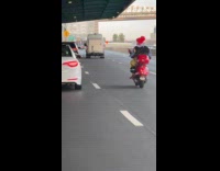 Clown in motorcycle chases car in road