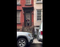 Man black shirt meditates on front step