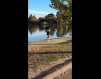 Woman jogs and films herself near lake