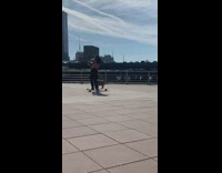 Guy dances while riding skateboard with dog