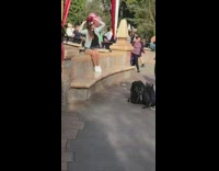 Girl with Minnie Mouse ears sits in front of Disneyland castle and takes a picture