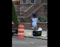 Inflatable snowman decoration outside apartment building shakes