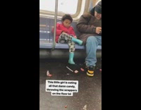 Little girl in pink jacket eating candy with wrappers on floor