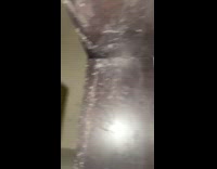 Black cat hiding in cabinet space below 