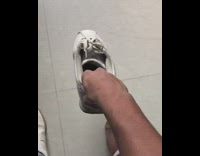 Guy throws shoes on feet wears them 