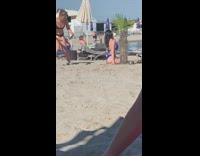 Woman blue bikini sit beside plant beach