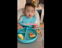 Sleepy baby boy eat in high chair