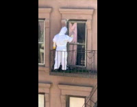 Person spray painting window wearing hazmat suit