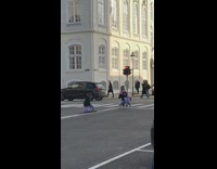 Girl sits in middle os street and takes pictures 