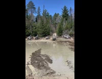 Person attempts to ride ATV through muddy waters but gets stuck