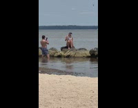 Woman bandana swimsuit sit on rock beach