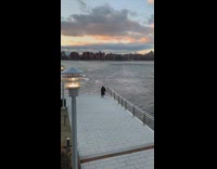 Man does a handstand on rail right next to river