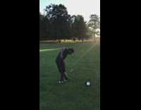 Guy juggles golf ball on golf club then uses other golf club to swing and hit ball