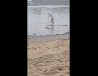 Man rides invented wooden platform on river