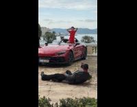 Woman red dress poses inside convertible car