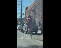Guy rides a very tall bike on the street