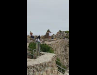 Girl white dress arms sideward rock ledge