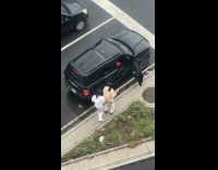 Couple dancing on sidewalk while waiting on traffic light