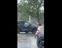 Shirtless man filming video dance in rain