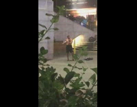 Shirtless man plays the flute in empty plaza penn station