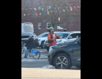 Man with clown makeup juggling pins at crosswalk