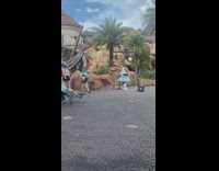 Woman in blue dress poses at the amusement park