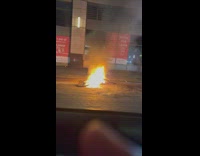 Bike engulfed in fire on the side of the road 
