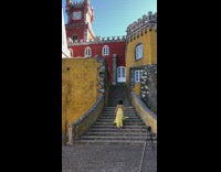 Yellow dress girl poses stairs red castle 
