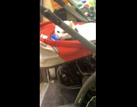 Cat riding the subway inside a baby stroller