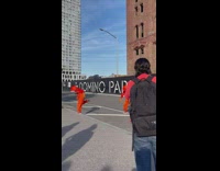 four guys in orange suits dance on the street