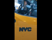 Guy drives yellow van with foot on dashboard 