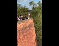 Woman white skirt poses edge of wall Part 2