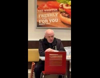 Man black jacket eats alone in restaurant