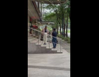 Man in pink polo poses at the mall stairs