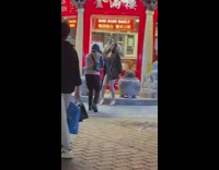 Man kisses woman on her neck on the street