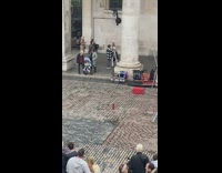 Woman silver bodysuit hold black jacket pillar