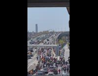 Bunch of bikers ride onto bridge 