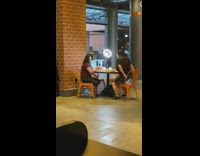 Two women with a ring light on the table