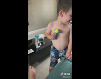 Small shirtless toddler boy hits mom on the knee with his toy hammer 
